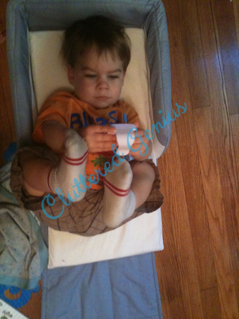 2 year old takes over newborn's travel bed.